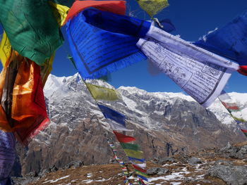 Colorful prayer flags waving against snowcapped mountains