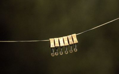 Close-up of clothespins hanging on rope outdoors