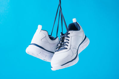 Close-up of shoes against blue background