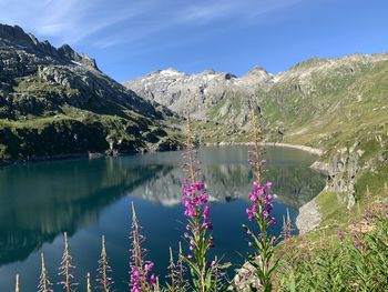 Scenic view of lake by mountains against sky