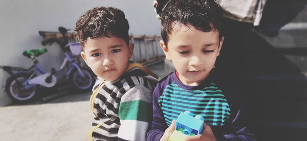 Cute kids holding toys standing outdoors