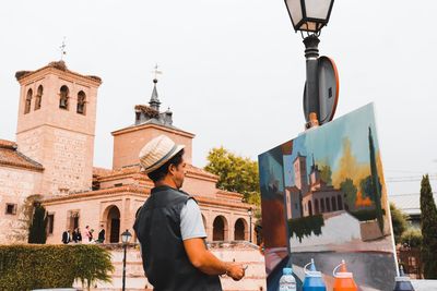 Low angle view of man amidst buildings in city