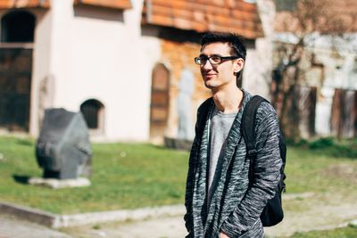 Portrait of young man standing against blurred background