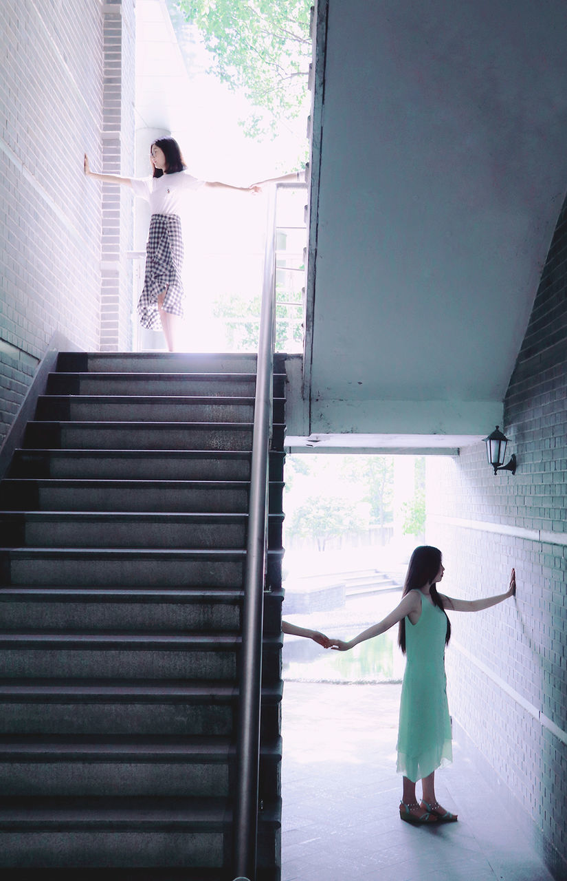 WOMAN STANDING BY WINDOW