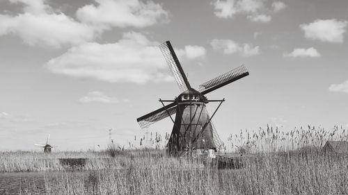 Traditional windmill on field against sky