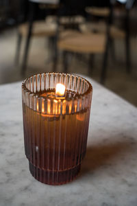 Close-up of illuminated candle on table