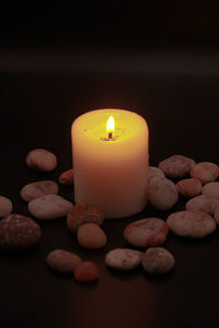 Close-up of lit candle against black background