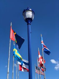 Low angle view of flag flags against blue sky