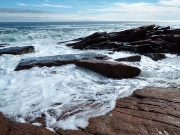 Scenic view of rocks on beach against sky