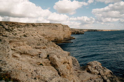 Rock formations by sea against sky