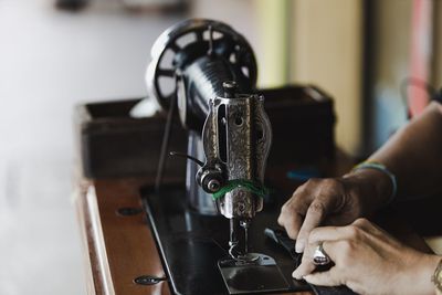 Close-up of woman using sewing machine