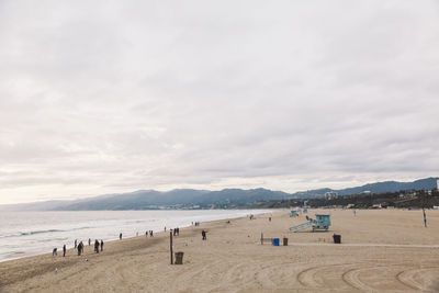 Scenic view of beach against cloudy sky