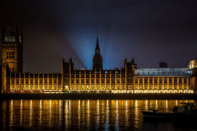 River with illuminated buildings in background at night