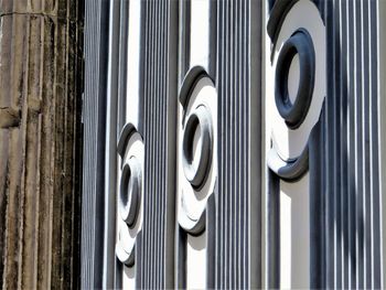 Close-up of metal fence against white wall