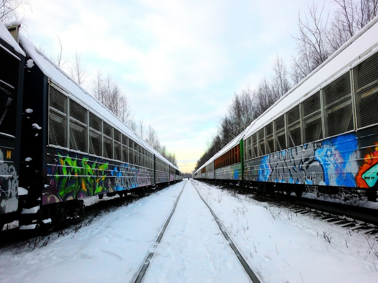 the way forward, diminishing perspective, transportation, snow, winter, cold temperature, graffiti, built structure, architecture, vanishing point, season, building exterior, road, street, bare tree, tree, weather, covering, city, sky
