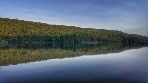 Scenic view of calm lake with mountains in background