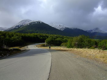 Road by mountains against sky