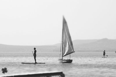 Man standing on sea against clear sky