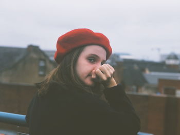 Portrait of young woman wearing hat against sky