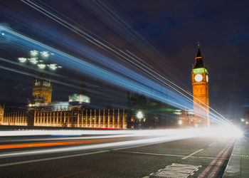 Light trails on road against sky at night