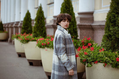 Rear view of woman standing by flowering plants