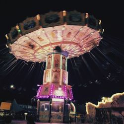 Low angle view of illuminated carousel at night