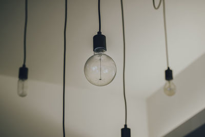 Low angle view of light bulb hanging from ceiling