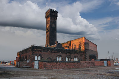 Old abandoned factory against sky