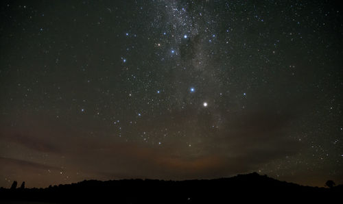 Silhouette landscape against sky at night