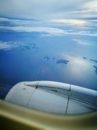 Close-up of airplane flying over sea against sky