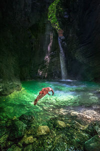 Man diving in river amidst mountain