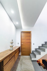 Distributor of a modern house, with stairs and light at the foot, wooden storage cabinet, door wood