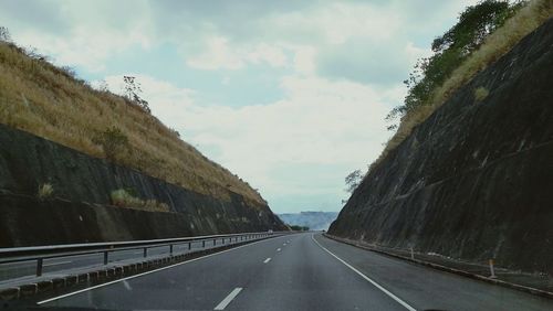 Road amidst buildings against sky