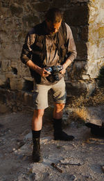 Portrait of young man standing against wall