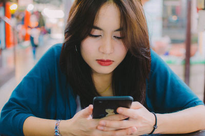 Woman using mobile phone at table