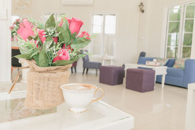 Beautiful bouquet of flowers in a coffee shop with coffee cup.