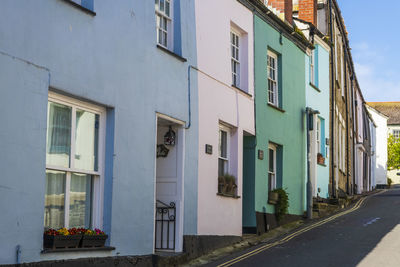 Residential buildings by road against sky in city