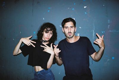 Portrait of friends standing against wall