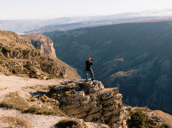 Man standing on rock against mountains