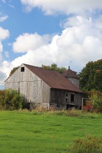 Barn on field against sky