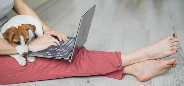 Cropped hands of woman using laptop