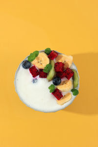 High angle view of food in plate on yellow background