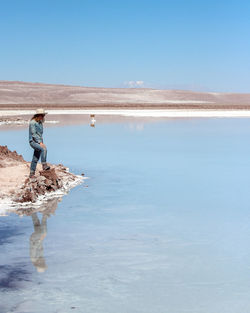 Full length of woman standing on beach against sky