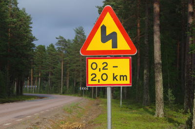 Information sign on road amidst trees