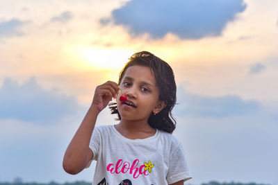 Portrait of girl holding camera red cherry during sunset