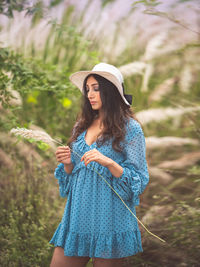 Young woman wearing hat standing on field