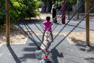 Girl playing while woman standing in playground
