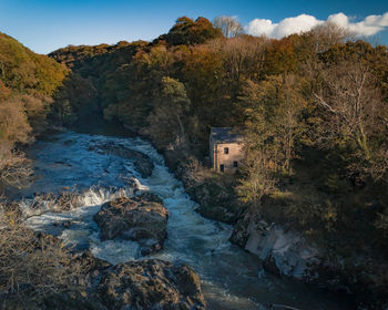 Scenic view of river amidst buildings against sky