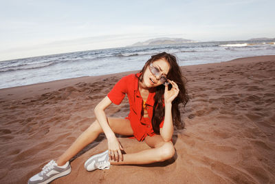 Portrait of young woman sitting at beach