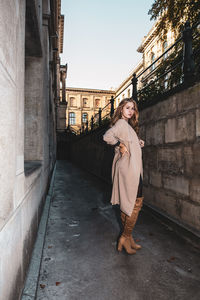 Portrait of woman standing by building in city